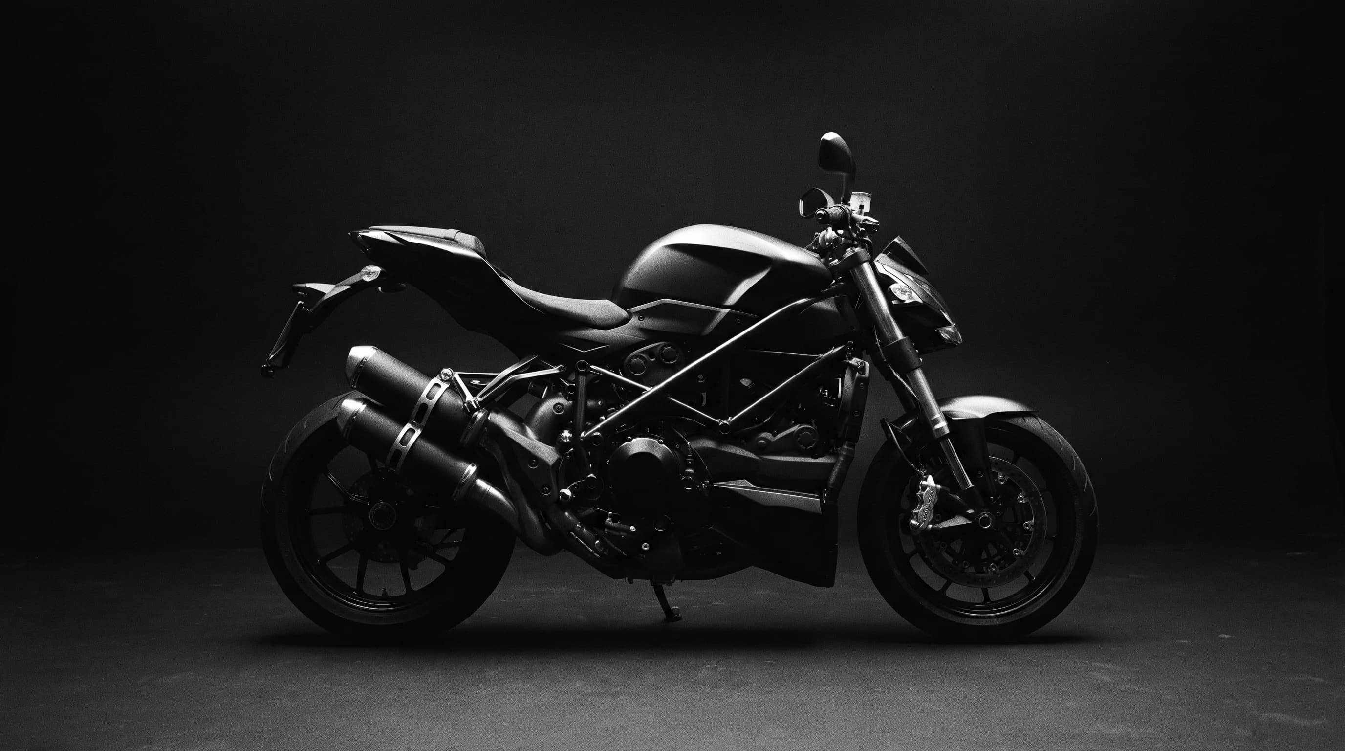 An unbranded motorcycle held in deep shadow with narrow edge highlights